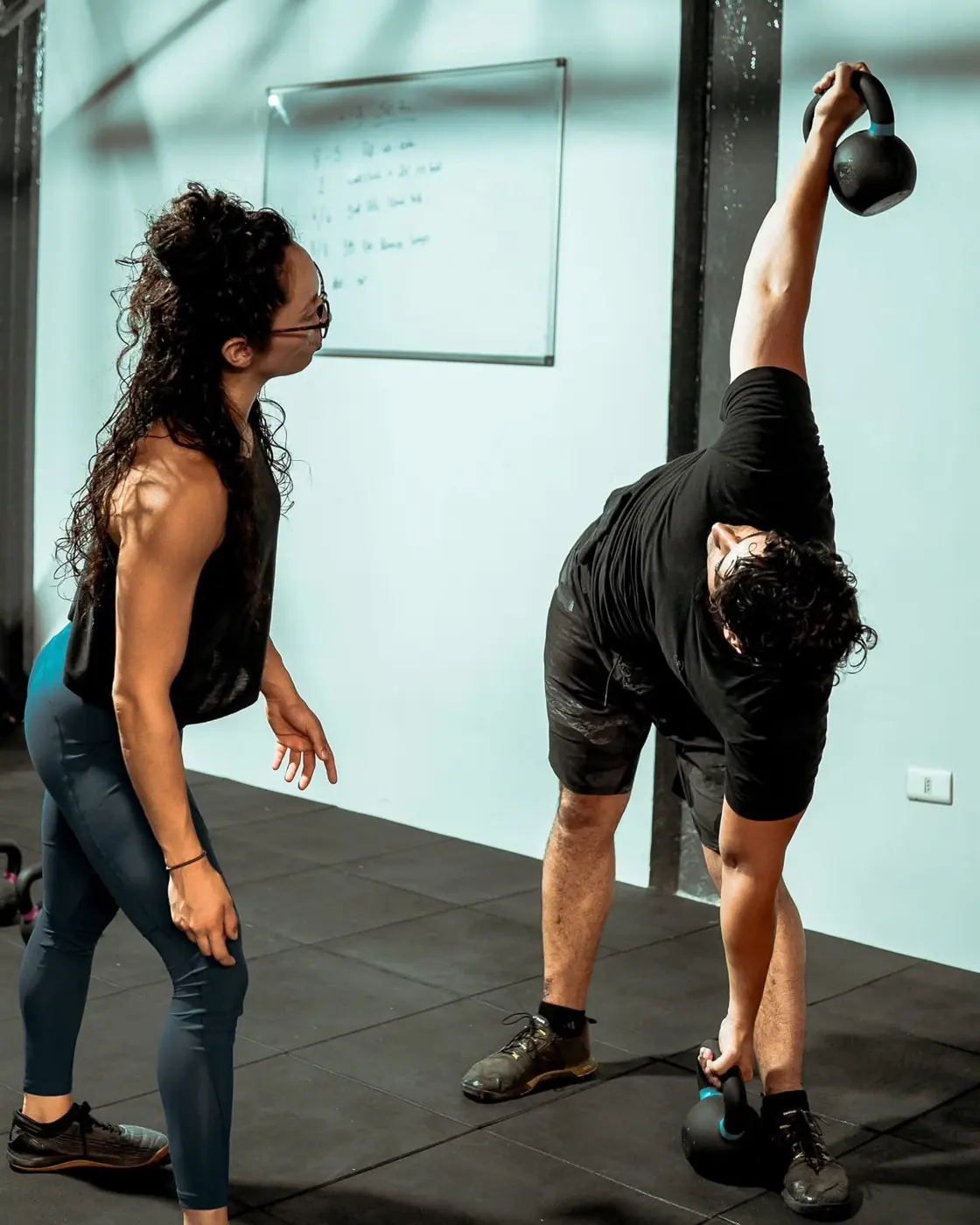 Niria guía a un atleta en un ejercicio con kettlebell